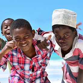 Three boys on a beach in Tanzania