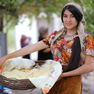 Tajikistan girl holding basket with bread Tajikistan girl holding basket with bread