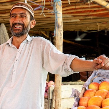 Man in Pakistan smiling while posing the hand on food basket