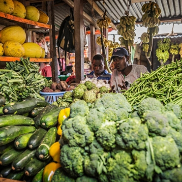 Two men selling vegetables in the market in Tanzania