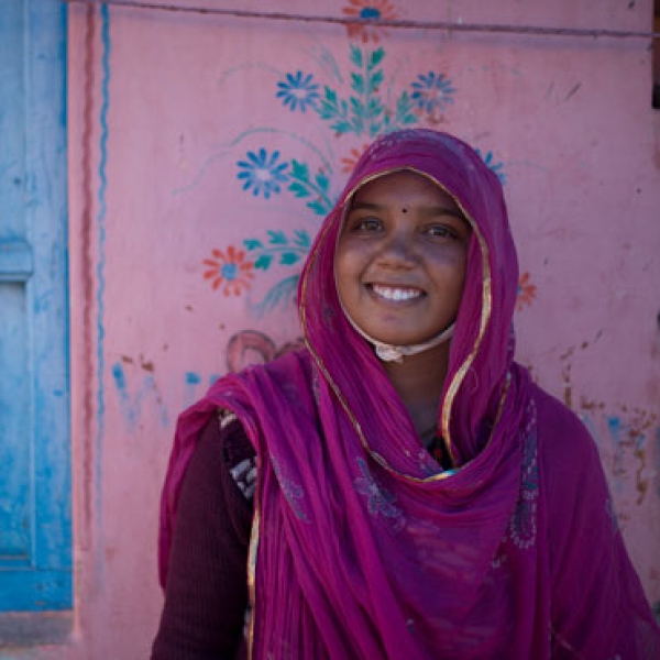 Woman with pink headscarf against wall